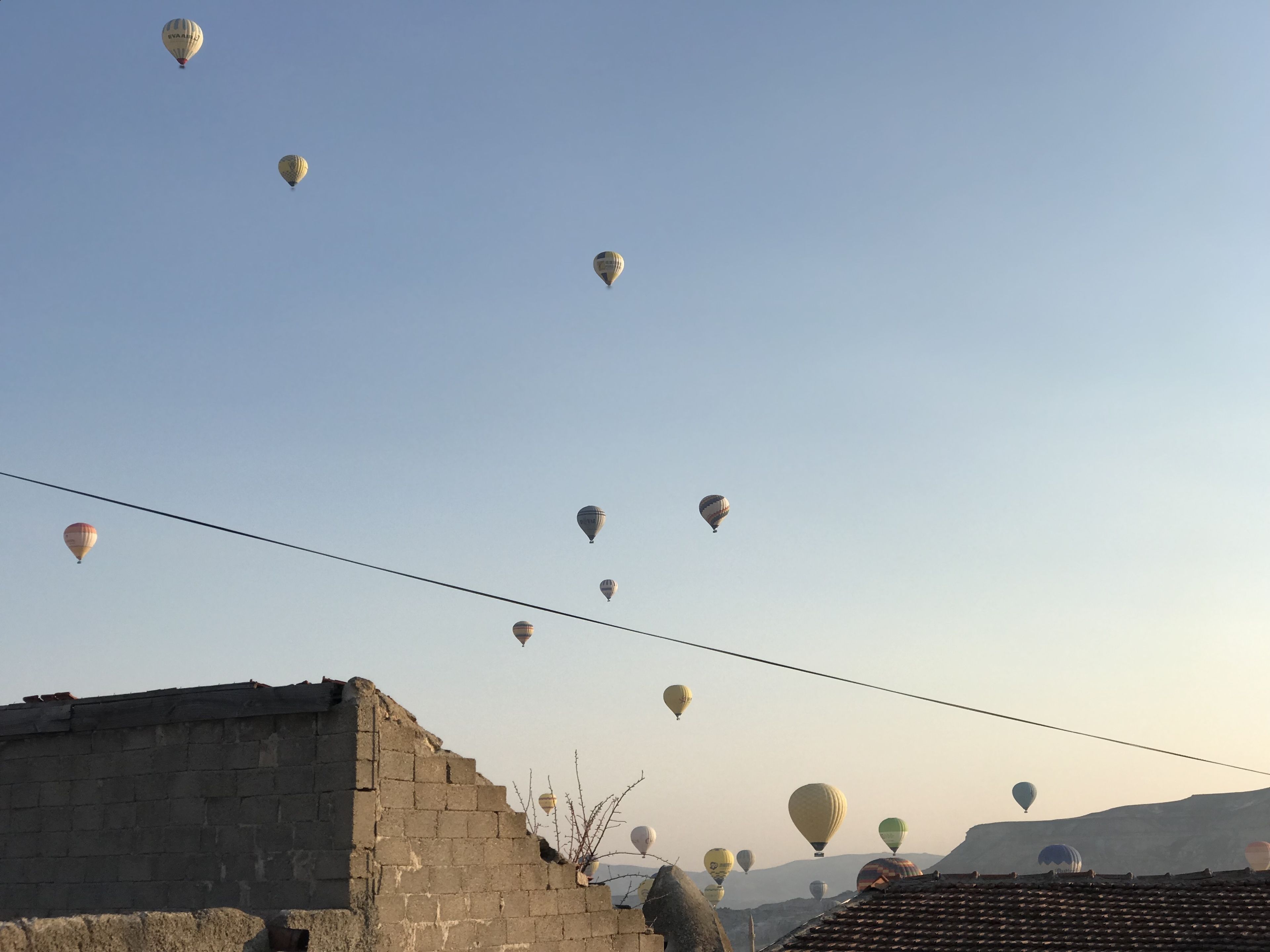 A clear sky with multiple hot air balloons in flight.