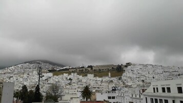 Una zona urbana densamente poblada, con edificios blancos y una colina destacada al fondo.