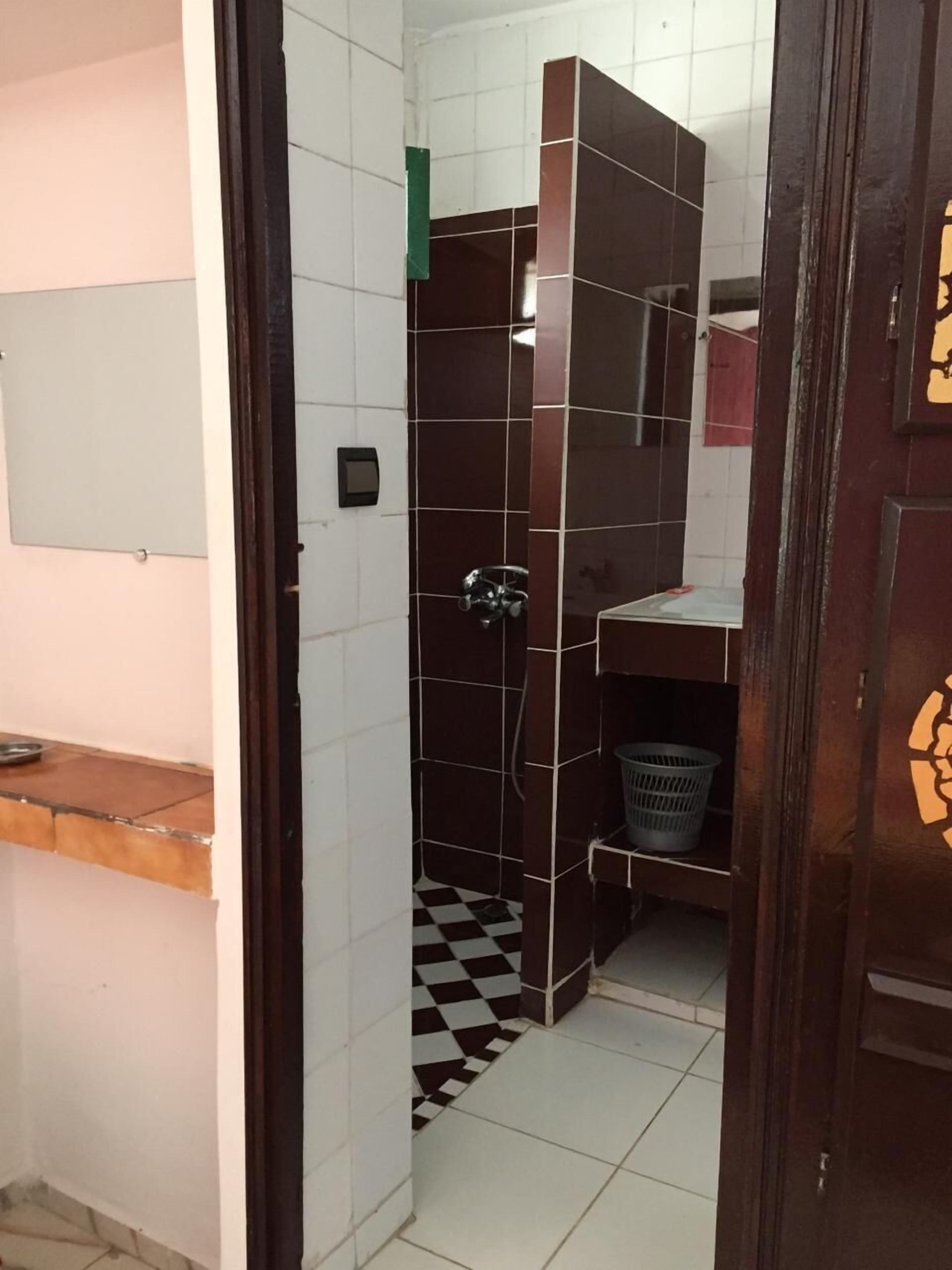 A small bathroom with a shower, a sink, and a toilet.