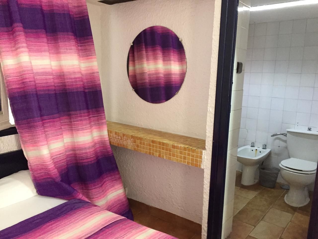Een badkamer met toilet, hygiëneschuimer en wastafel.