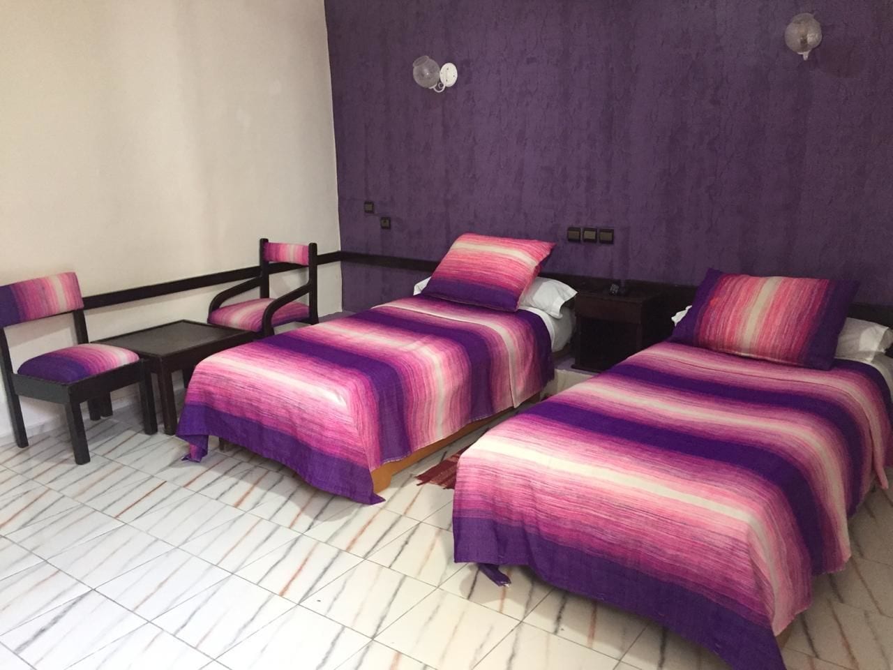 Una habitación con dos camas, un escritorio y una silla.