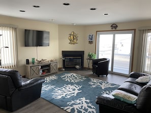Relax in this stylish living room with a flat-screen TV, fireplace, and comfortable leather sofas.