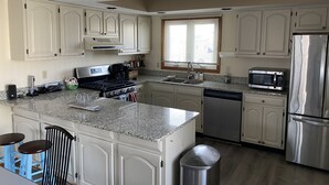 A kitchen with white cabinets, a stainless steel refrigerator, a microwave, a stove, and a dishwasher. - Ocean Views, Watch the breakers from the Deck; B side (Brigantine)