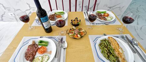 A dining table with various dishes, a bottle of wine, and cutlery.