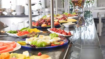 Un bufé con frutas, verduras y comidas preparadas.