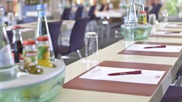 Un comedor de hotel con mesas dispuestas para el servicio, cristalería transparente y condimentos.