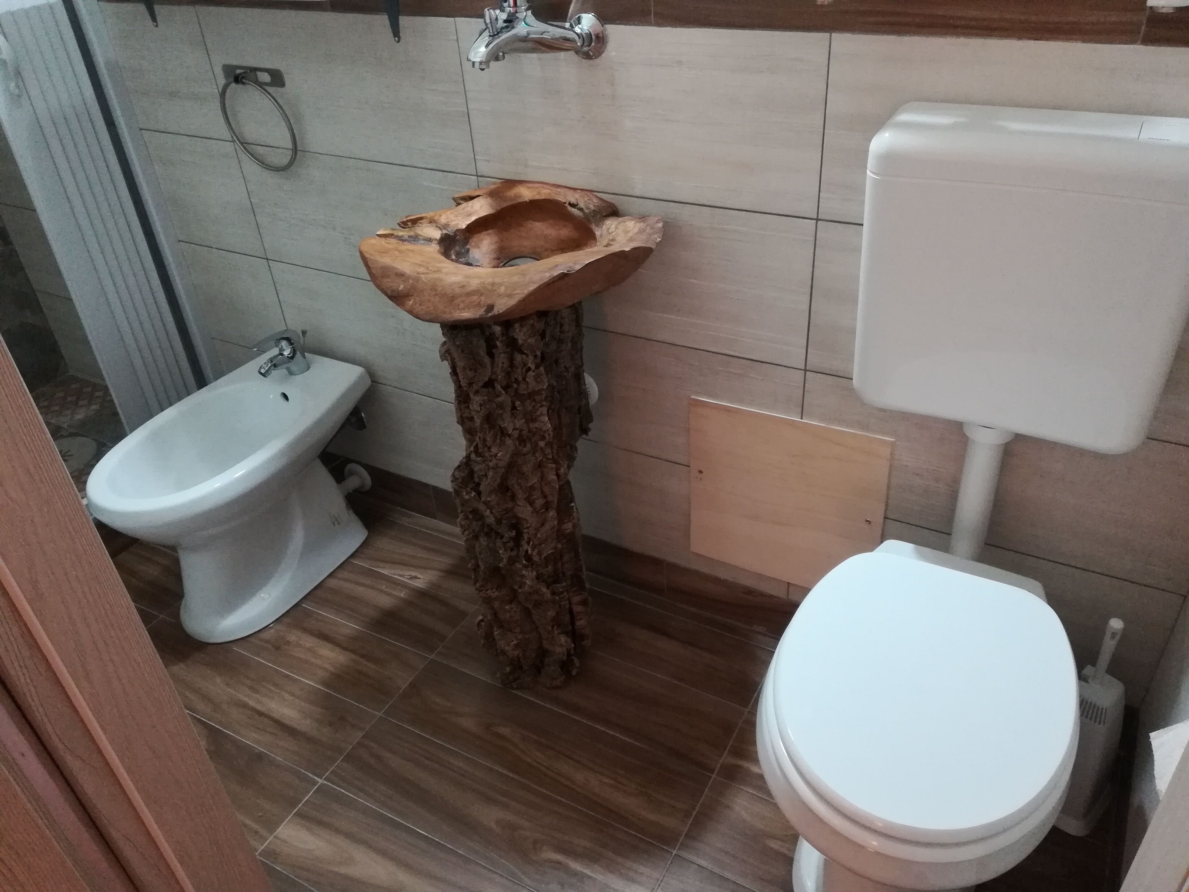 Kylpyhuone, jossa on puinen pesuallas, bidee ja wc.