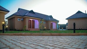 A residential building with a paved driveway, a well-maintained lawn, and a clear sky.