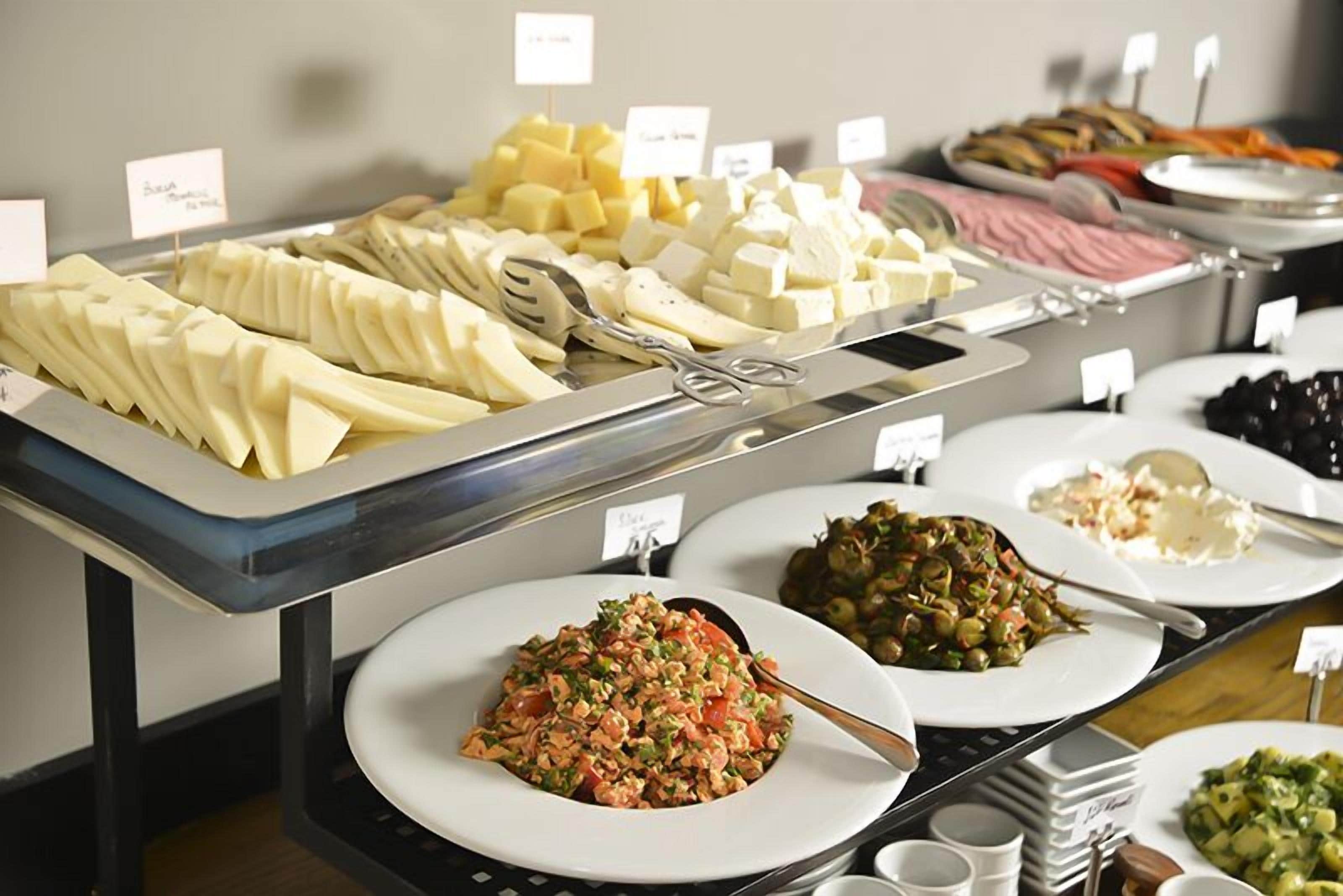 A buffet with various food items including cheese, salads, and other dishes.