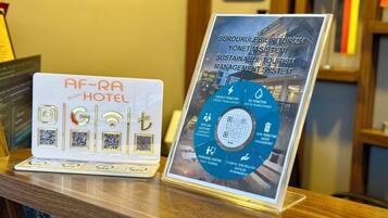 Un panneau d’affichage présentant un schéma circulaire intitulé « Système de gestion du tourisme durable » et un ordinateur portable doté d’étiquettes NFC.