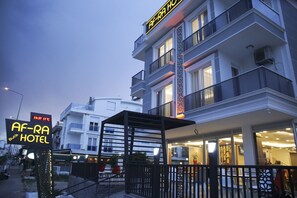 A hotel with a modern facade, a balcony area, and a sign indicating the name and temperature. - Af-Ra Hotel (Konyaalti)