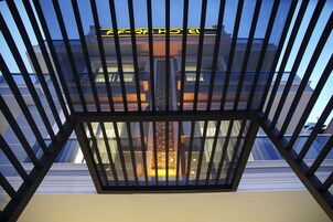 A modern building with a glass facade and a metal railing.