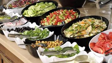 Un bufé con ensaladas y verduras variadas.