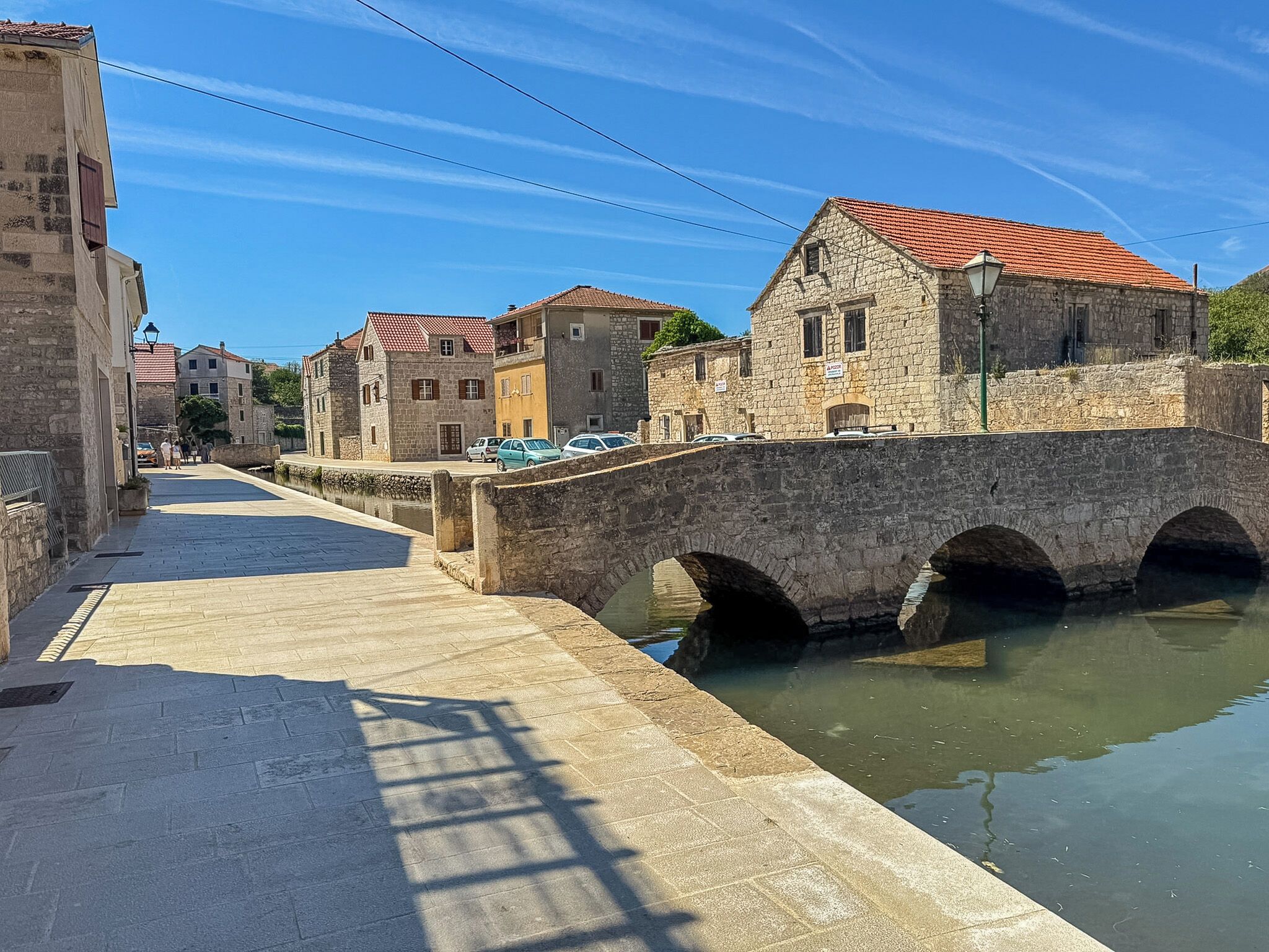 A stone bridge over a canal with buildings on either side.
