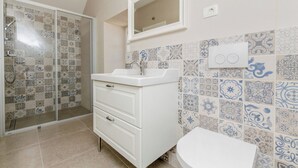 A bathroom with a shower, a sink, and a toilet. - House Morko1 (Vrboska)