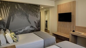 A hotel room with two beds, a TV, a wooden desk, and a wall with a palm tree mural. - Rio Hotel by Bourbon Campinas (Campinas)