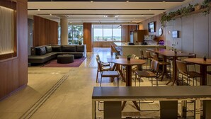 A modern hotel lobby with a seating area, a bar, and a dining space. - Rio Hotel by Bourbon Campinas (Campinas)