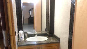 Une salle de bain avec un lavabo, un miroir et des meubles en bois.