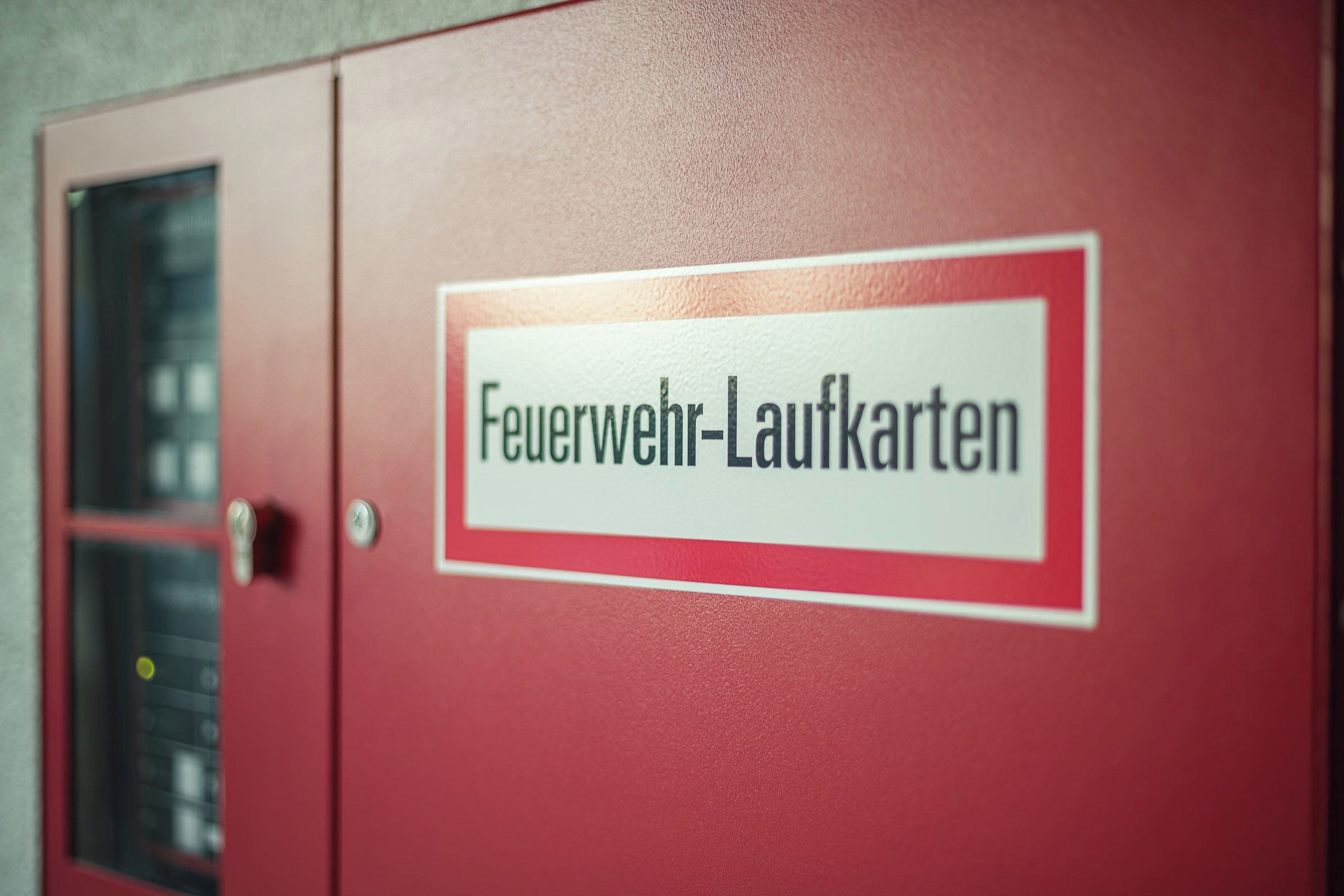 A red cabinet with a label that reads "Feuerwehr-Laufkarten".