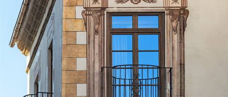 A building facade with a classical architectural style, featuring a window with a balcony.