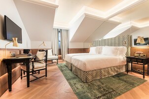 Un dormitorio moderno con una cama grande, un escritorio, una silla y un televisor.