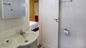 A bathroom with a sink, mirror, and toilet. - Rio Rentals 021 - C005 Studio em Copa (Rio de Janeiro)