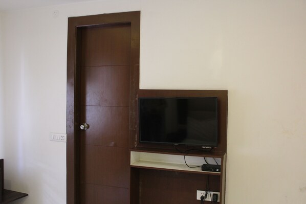 A wooden door with a television mounted on a shelf above it.