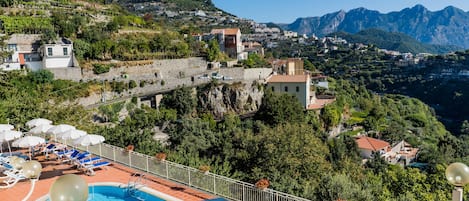 Una piscina al aire libre de temporada, sombrillas