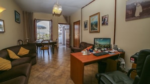Habitación de hotel con comedor, escritorio y vistas al exterior.