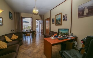 Habitación de hotel con comedor, escritorio y vistas al exterior.