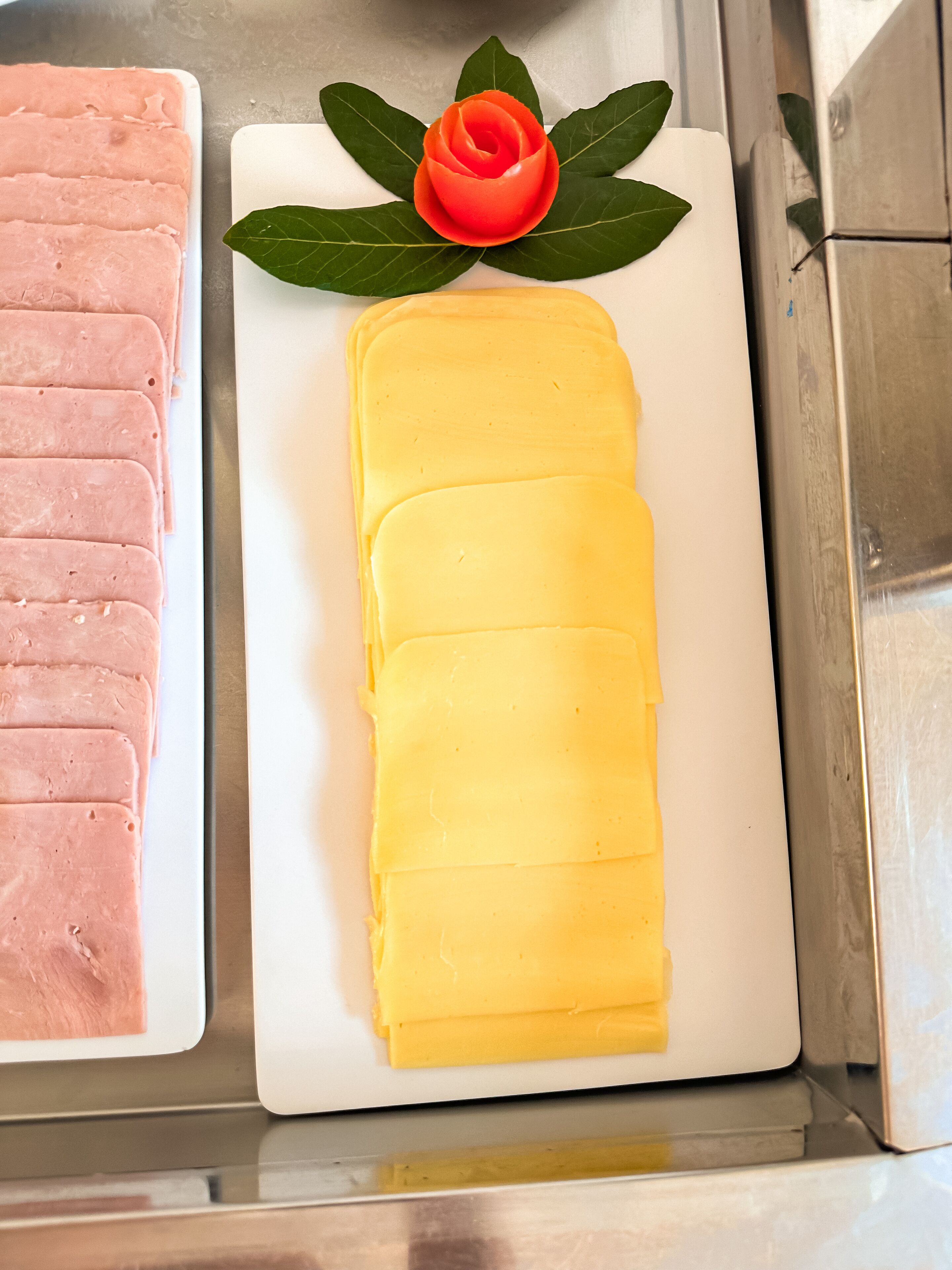 A display of sliced meats and cheeses in a refrigerated case.