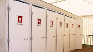 A row of white lockers with red female symbols and a white female symbol on the doors. - GPtents- Munich Oktoberfest (Munich)
