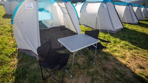 A row of camping tents with a table and chairs set up in front. - GPtents- Munich Oktoberfest (Munich)