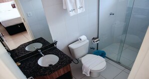A bathroom with two sinks, a toilet, and a shower.