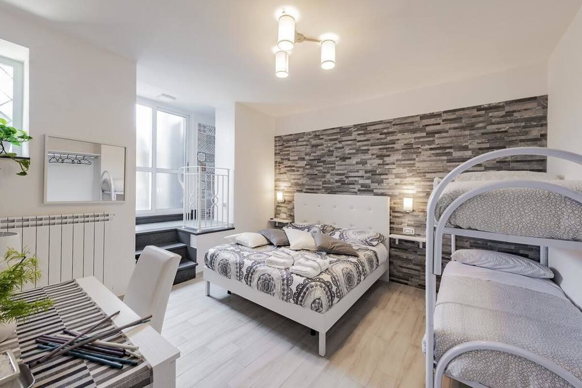 Quarto moderno com cama, escrivaninha e beliche.