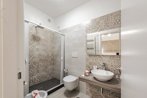 A modern bathroom with a shower, toilet, and sink. - Terra Mia (Pompei)