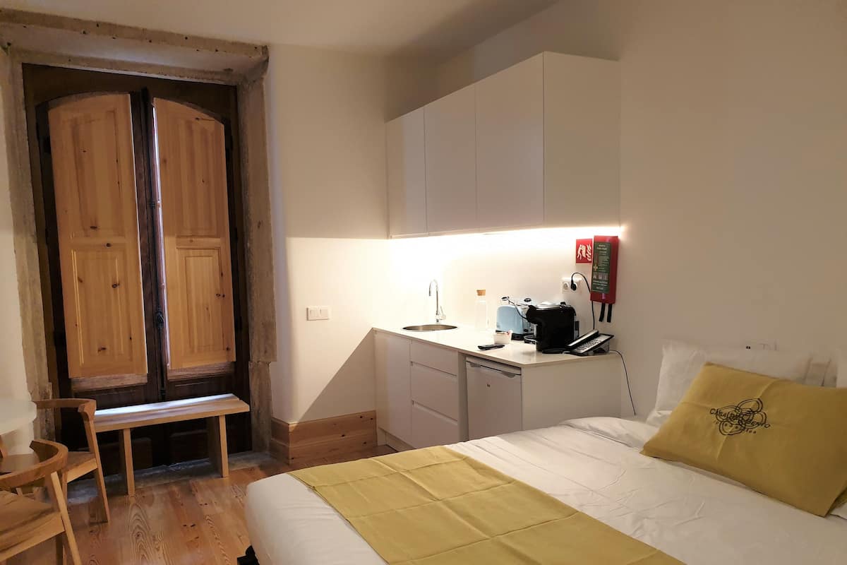 Une chambre à coucher comprenant un lit, une table de chevet et un bureau avec une chaise.