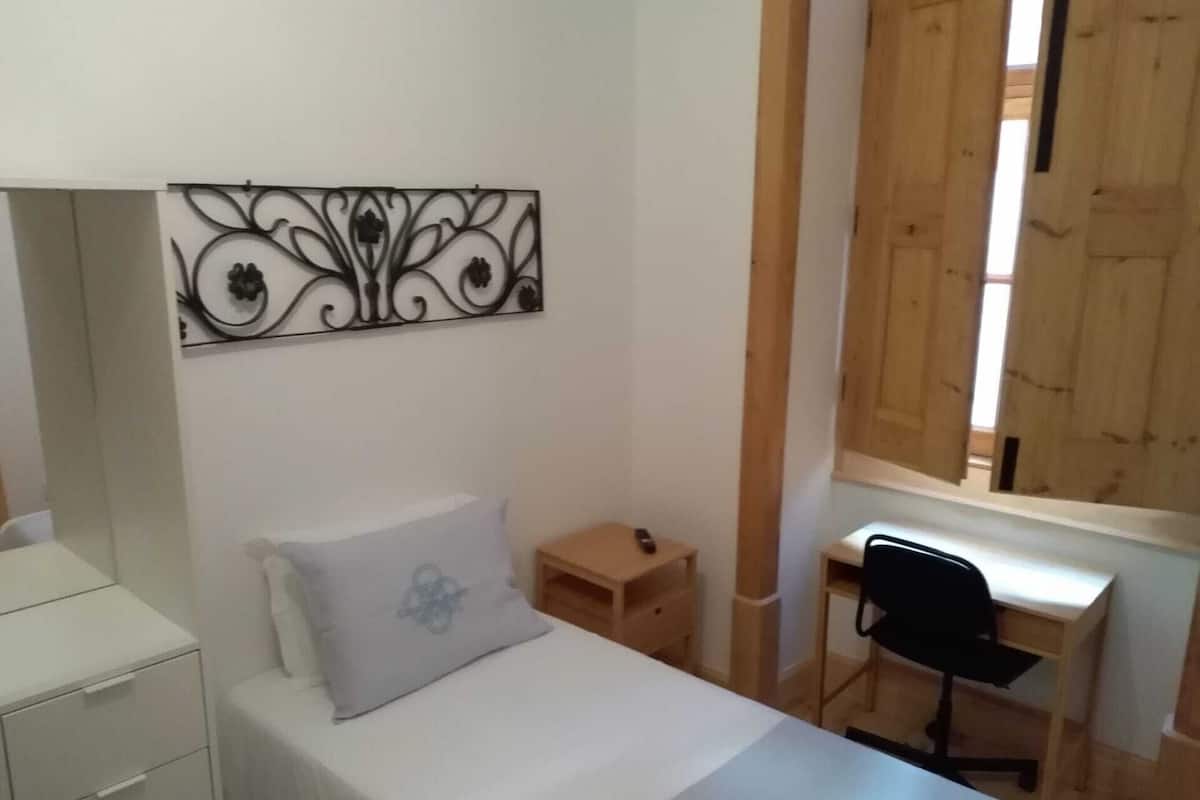 Une chambre à coucher avec un lit, un bureau et une chaise.