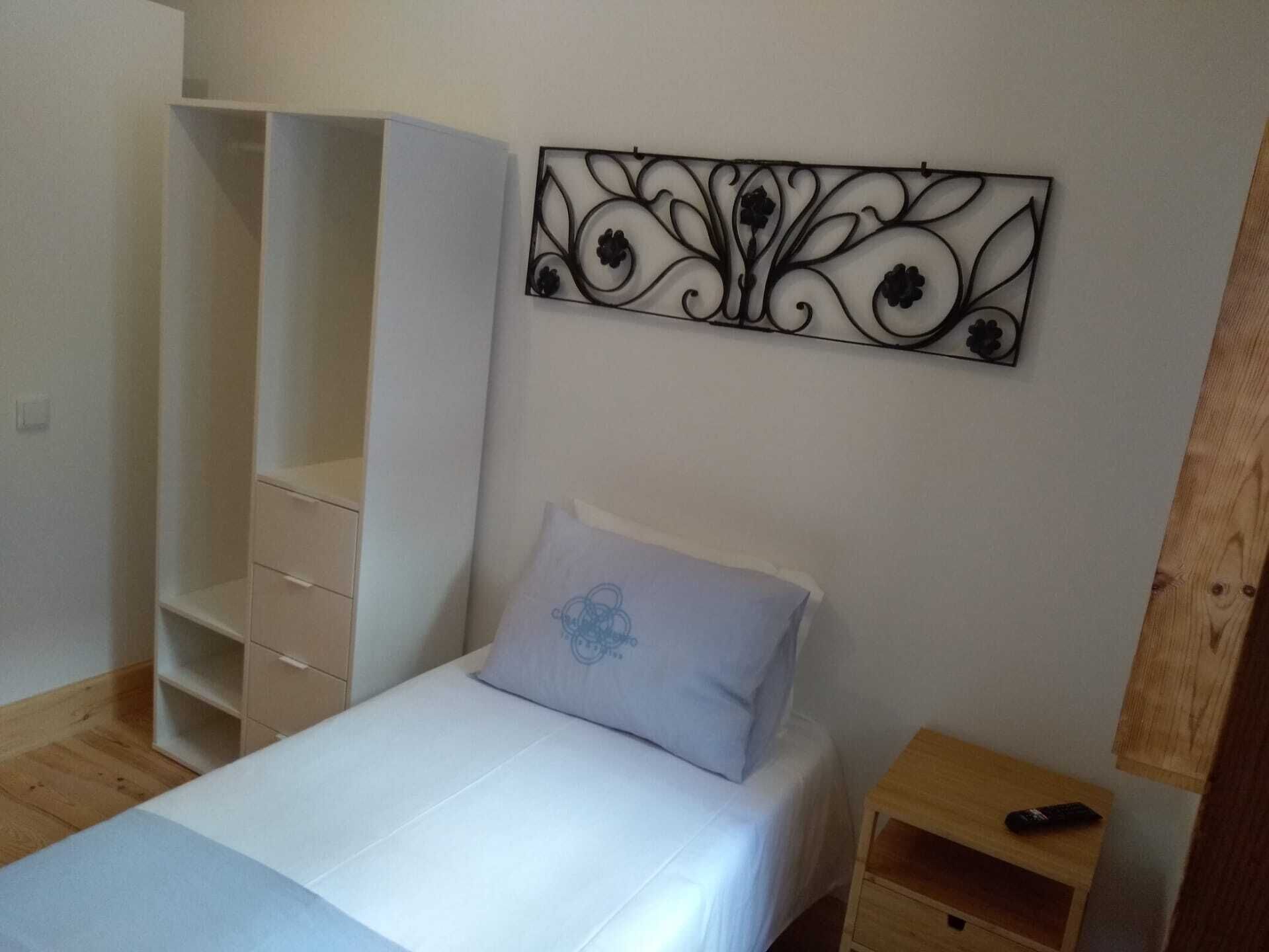 Une chambre à coucher comprenant un lit, une armoire, une table de chevet et un élément décoratif mural.