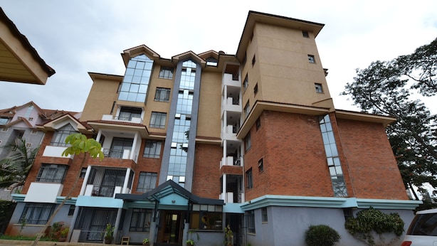 A multi-story hotel with a central entrance, a parking area, and a mix of brick and glass facades. - Lighthomez Angles Heights (Nairobi)