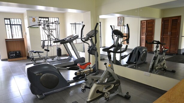 Un gimnasio con equipo de ejercicio variado, incluyendo cintas de correr, elípticas y máquinas de pesas.