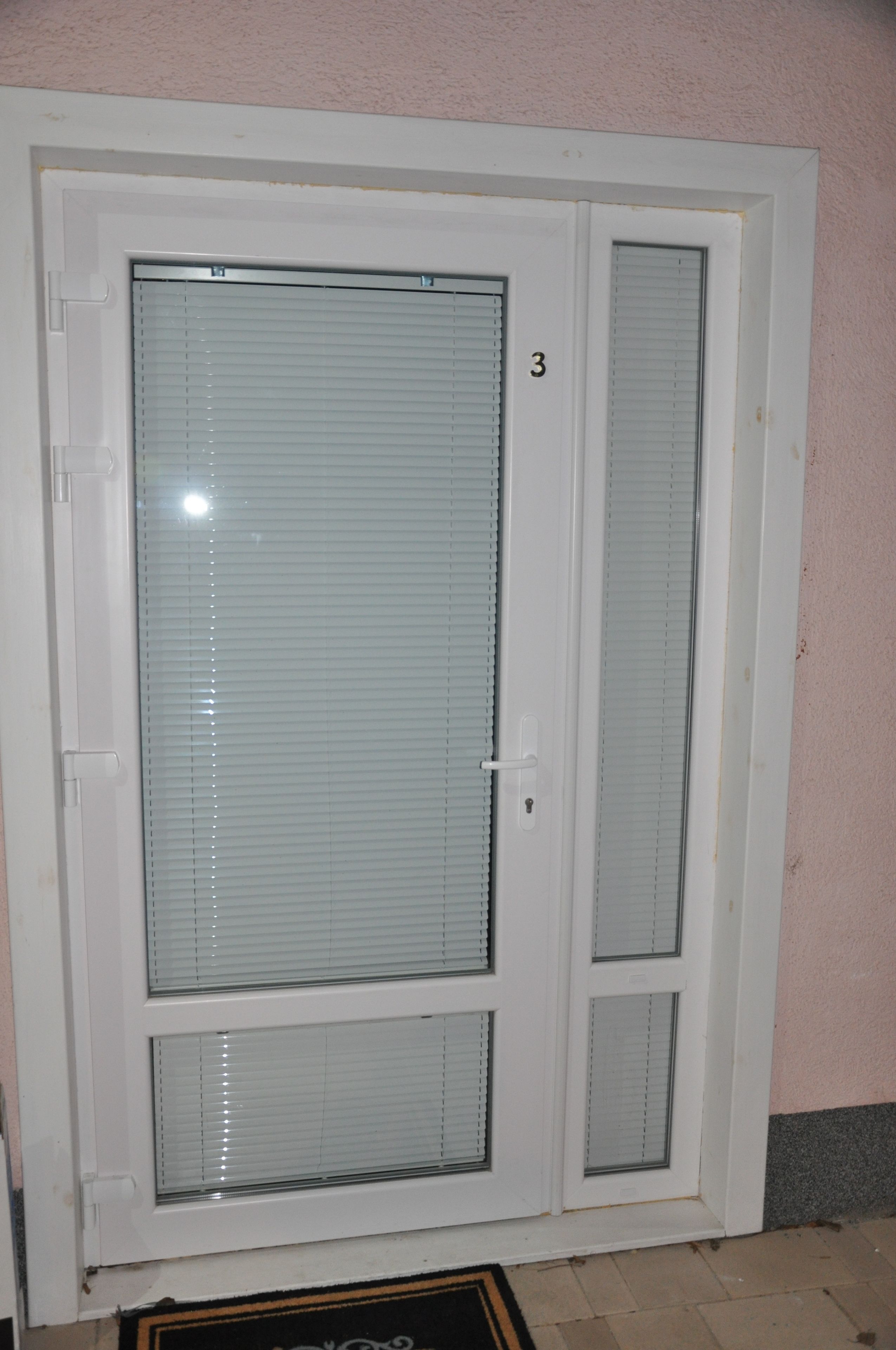A white door with a glass panel and a small window, marked with the number 3.