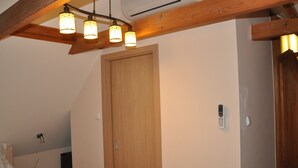 Ein Zimmer mit Holzboden, einer Tür und einer Wand-Klimaanlage.