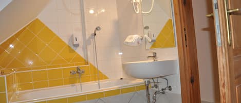A bathroom with a bathtub, a sink, and a shower.