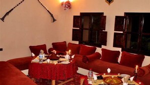Un comedor acogedor con mantel rojo, velas y una disposición tradicional para la comida.