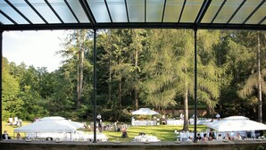 An outdoor event with tents and tables set up in a grassy area surrounded by trees. - Schloss Lanke (Wandlitz)