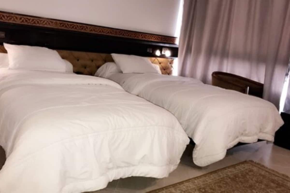 A double bed with white bedding in a hotel room.