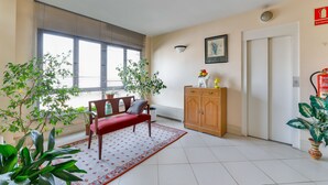 Une pièce spacieuse avec un canapé rouge, un meuble en bois et un radiateur.