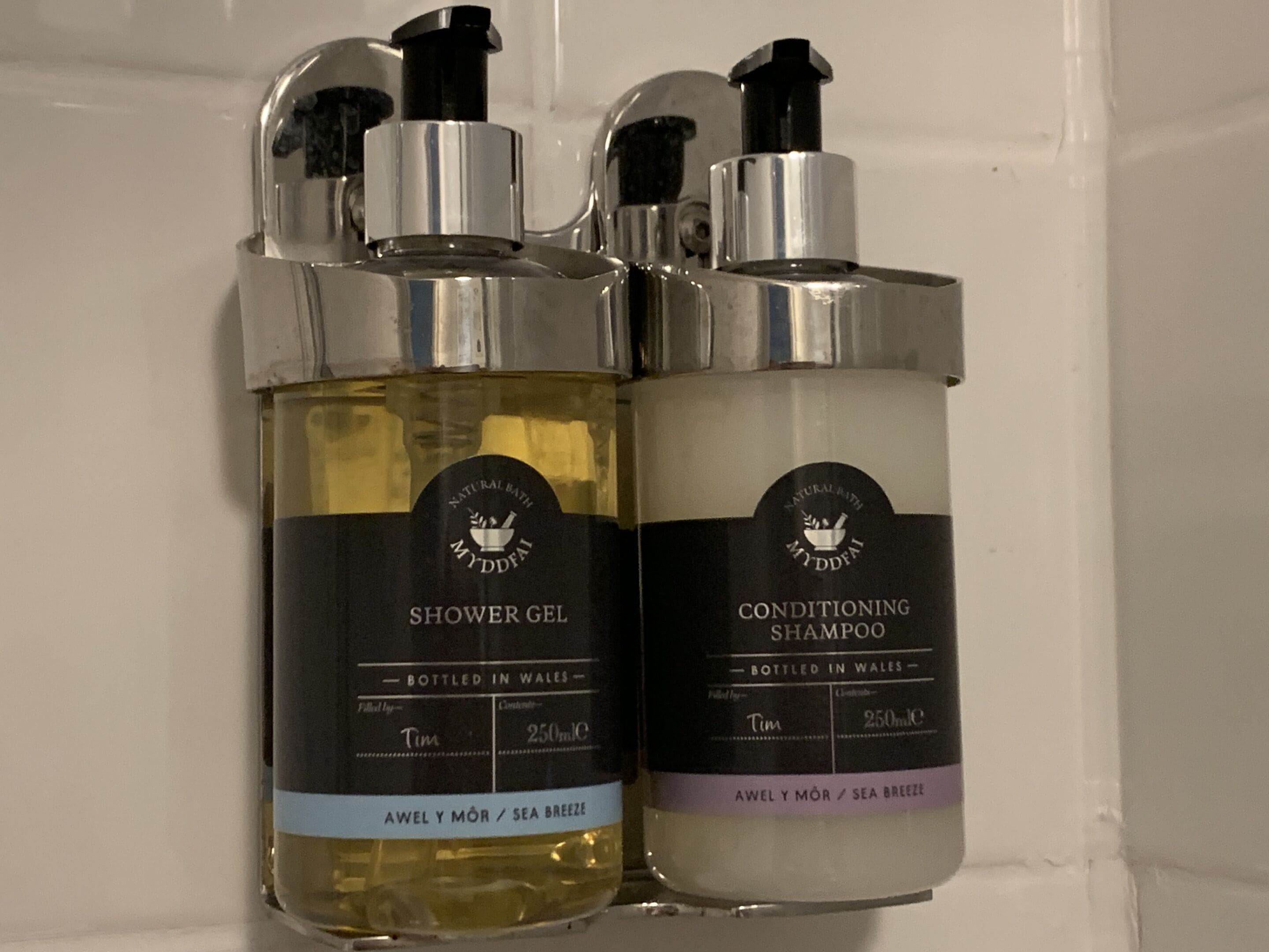 Two bottles of shower gel and conditioning shampoo, both labeled 'Natural Bath MyDffai' and 'Awel Y Môr / Sea Breeze'.