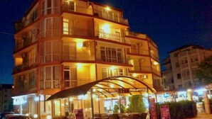 Un hotel a più piani con balconi, posti a sedere all'aperto e un ingresso coperto.